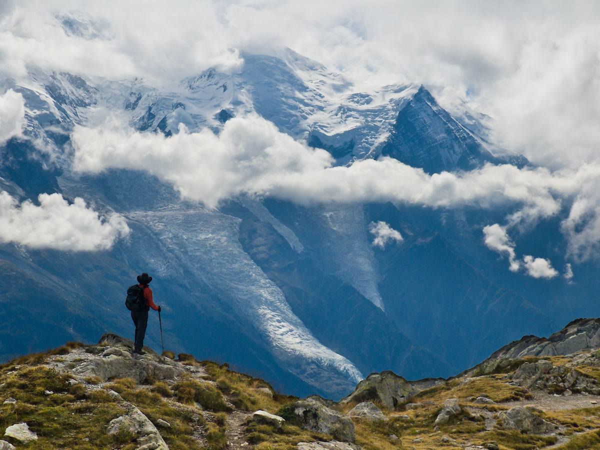 Haute Route: hiker stands on a trail overlooking beautiful, snowy mountains