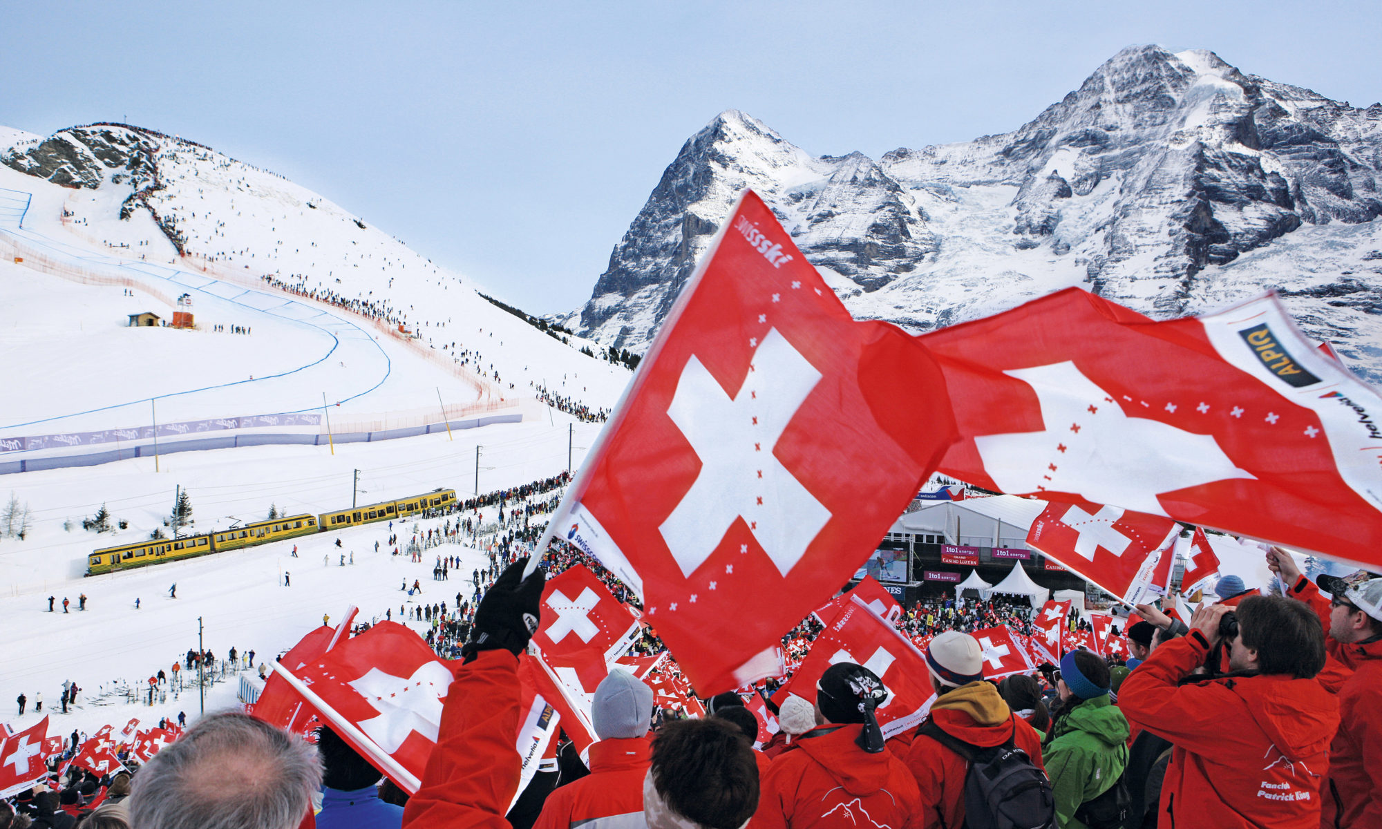 Swiss flags in front of snowy mountains, in the best country in the world.